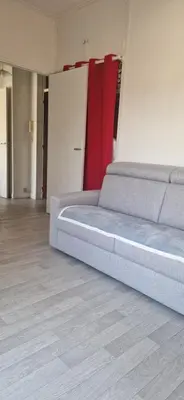 a bed in a room with a red curtain at NICE STUDIO 26m2 avec TERRASSE 16m2 in Nice