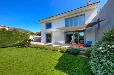 a white house with orange chairs in a yard at Villa Contemporaine à Carros les plans in Carros