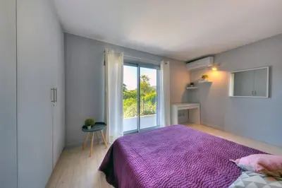a bedroom with a purple bed and a window at Villa Contemporaine à Carros les plans in Carros