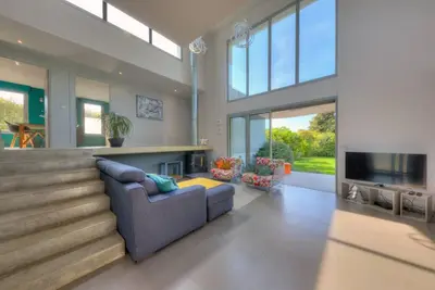 a large living room with a couch and a tv at Villa Contemporaine à Carros les plans in Carros