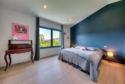 a bedroom with a large bed and a piano at Villa Contemporaine à Carros les plans in Carros