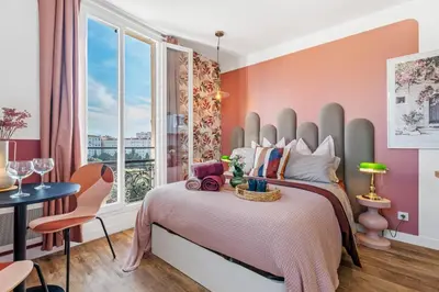 a bedroom with a bed with pink walls and a window at Nice Renting - CAMBRAI03 - Seaside Studio on the Promenade des Anglais in Nice
