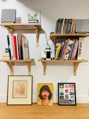 a shelf with books and pictures on a wall at Appartement Vieux Nice Garibaldi rénové in Nice