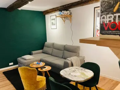 a living room with a couch and a table and chairs at Appartement Vieux Nice Garibaldi rénové in Nice