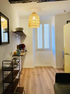 a living room with a large window and a pendant light at Appartement Vieux Nice Garibaldi rénové in Nice