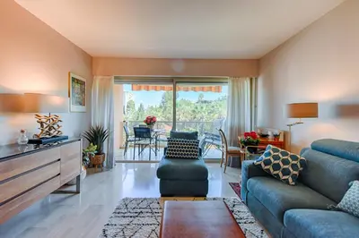 a living room with a couch and a table and chairs at Happyfew Sainte Anne in Nice