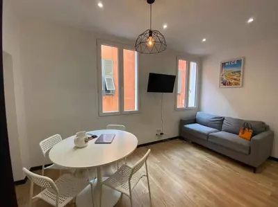 a living room with a table and a couch at Charming Apartment in Nice in Nice