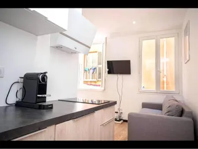 a kitchen with a counter and a couch in a room at Charming Apartment in Nice in Nice
