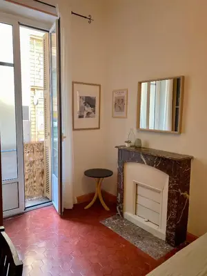 a living room with a fireplace and a mirror at Cosy Blue Nice in Nice