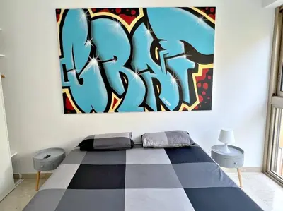 a bedroom with a bed with a painting on the wall at Carré d'or Studio 2 in Nice