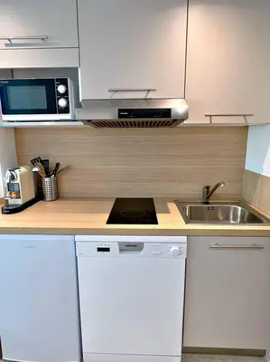 a kitchen with white cabinets and a sink at Carré d'or Studio 2 in Nice