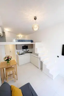 a white kitchen with stairs and a table in a room at Studio à louer au cœur du Carré d or à Nice, rue Dalpozzo à 150 mètres des plages in Nice