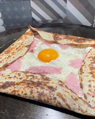 two slices of pizza with an egg on a pan at Studio à louer au cœur du Carré d or à Nice, rue Dalpozzo à 150 mètres des plages in Nice