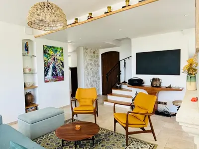 a living room with yellow chairs and a tv at Paisible et Spacieuse Villa avec 4 suites indépendantes in La Gaude