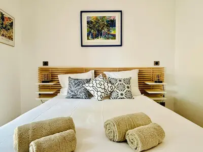 a bedroom with a large white bed with pillows at Paisible et Spacieuse Villa avec 4 suites indépendantes in La Gaude
