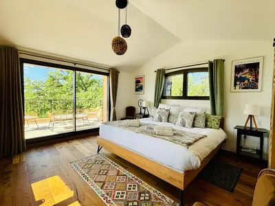 a bedroom with a bed and a large window at Paisible et Spacieuse Villa avec 4 suites indépendantes in La Gaude