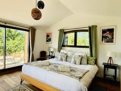 a bedroom with a large bed and a balcony at Paisible et Spacieuse Villa avec 4 suites indépendantes in La Gaude