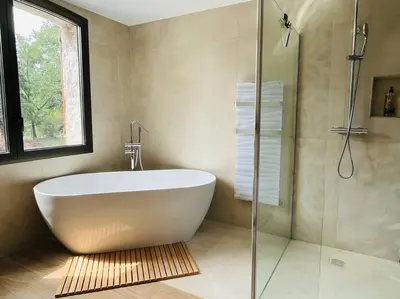 a bathroom with a tub and a glass shower at Paisible et Spacieuse Villa avec 4 suites indépendantes in La Gaude