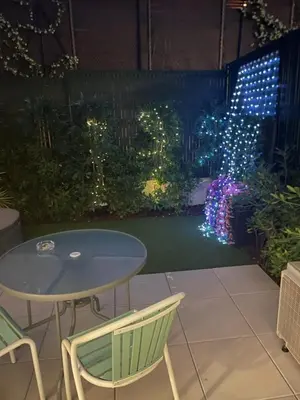 a patio with a table and chairs and lights at Chez Candie in La Trinité