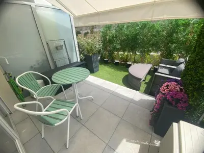 a patio with a table and chairs and a garden at Chez Candie in La Trinité
