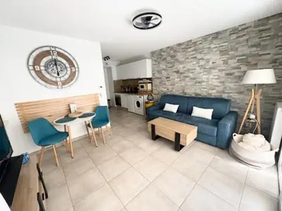 a living room with a blue couch and a table at Chez Candie in La Trinité