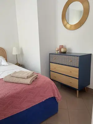 a bedroom with a bed and a dresser with a mirror at 2/3 pièces avec terrasse à NICE in Nice