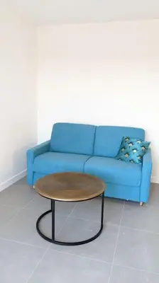 a blue couch and a coffee table in a room at 3 pièces dans villa avec piscine in Nice