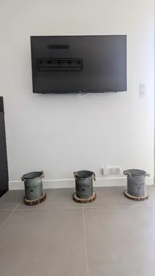 two buckets in front of a tv on a wall at 3 pièces dans villa avec piscine in Nice