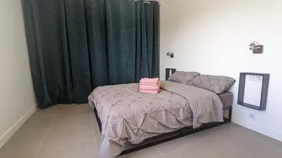 a bedroom with a bed with a green curtain at 3 pièces dans villa avec piscine in Nice
