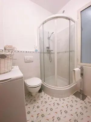a white bathroom with a shower and a toilet at BEAUTIFUL renovated apartment ,NEXT TO THE BEACH ! AIR-C, FREE PARKING! in Nice