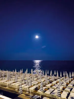 a beach with chairs and the ocean at night at BEAUTIFUL renovated apartment ,NEXT TO THE BEACH ! AIR-C, FREE PARKING! in Nice