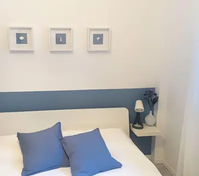 a bedroom with a bed with two blue pillows at BEAUTIFUL renovated apartment ,NEXT TO THE BEACH ! AIR-C, FREE PARKING! in Nice