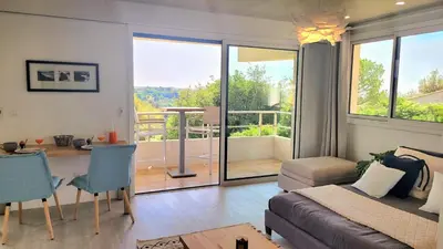 a living room with a bed and a dining room with a view at Studio climatisé vue imprenable wifi in Vence
