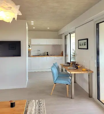 a kitchen with a table and a blue chair at Studio climatisé vue imprenable wifi in Vence