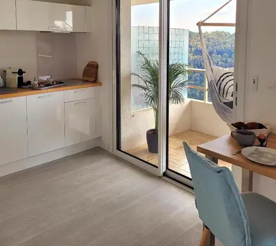 a kitchen with a hammock in front of a window at Studio climatisé vue imprenable wifi in Vence
