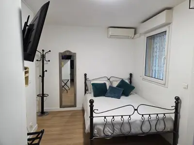 a small kitchen with white cabinets and a desk at Aya's Studio in Nice