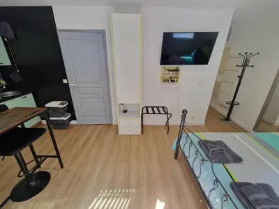 a room with a bed and a desk and a tv at Aya's Studio in Nice