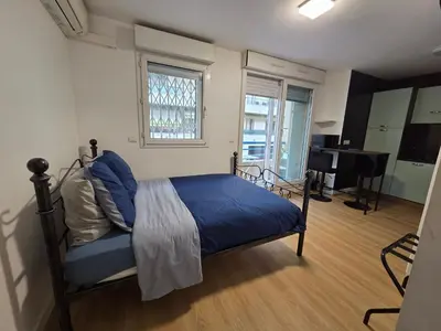 a bedroom with a bed and a large window at Aya's Studio in Nice