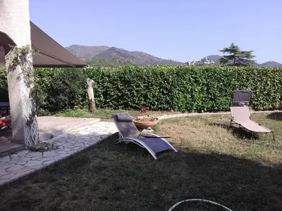 two chairs sitting on the grass in a yard at VILLA DE CHARME sur la Côte d'Azur in Tourrette-Levens