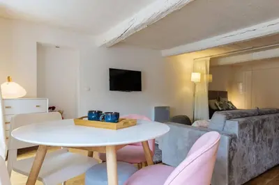 a living room with a white table and pink chairs at Joli loft entre le vieux Nice et le port in Nice