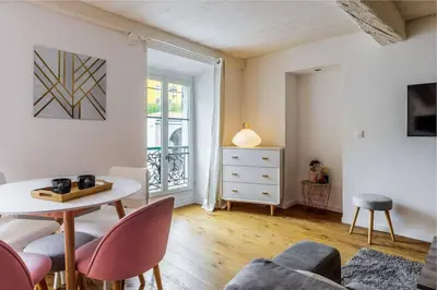 a living room with a table and chairs and a window at Joli loft entre le vieux Nice et le port in Nice