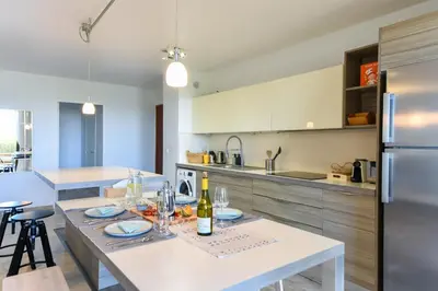 a kitchen with a table with a bottle of wine on it at Happyfew Le Flora in Nice
