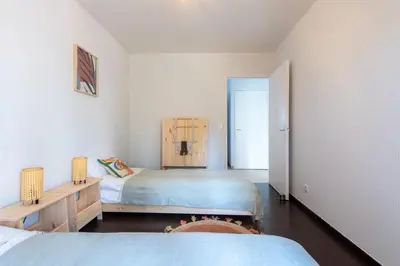 two beds in a room with white walls at Happyfew Le Flora in Nice