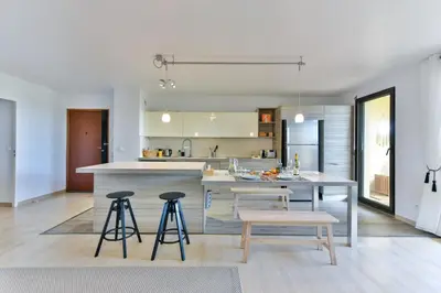 a kitchen with a table and stools and a counter at Happyfew Le Flora in Nice