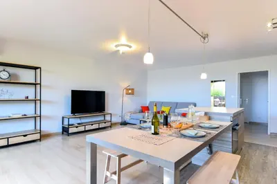 a living room with a table and a tv at Happyfew Le Flora in Nice