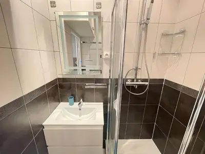 a small bathroom with a sink and a shower at Spacieux Loft Cœur Vieux Nice in Nice