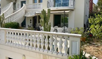 a garden with potted plants and flowers on a porch at Appartement en rez de jardin dans villa à Nice in Nice