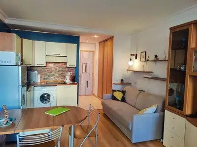a kitchen and living room with a couch and a table at Central close to beaches and shops, up till 6 pers in Nice