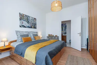a bedroom with a bed with a blue and yellow blanket at The place to be in Nice in Nice