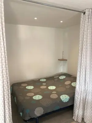 a bedroom with a bed and curtains in a room at Superbe appartement au calme et vue sur la mer in Cagnes-sur-Mer
